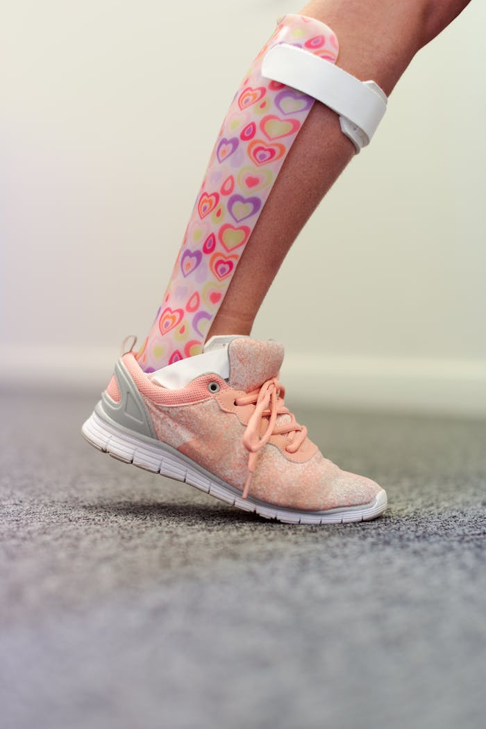 Close-up of an ankle foot orthosis with a playful design on a child's leg wearing a sneaker.